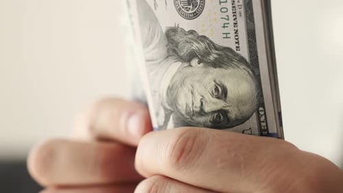 Hand Holds Stack of Hundred Dollar Bills