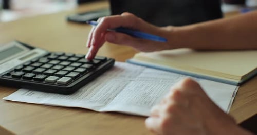 Closeup Tax and Calculation By Business Person Female Accountant Making Calculations and Taking