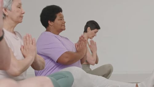 Group of Mature Women Meditating in Yoga Studio