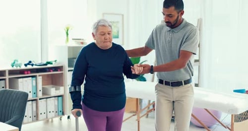 Senior Woman Assisted Walking with Crutches in Clinic
