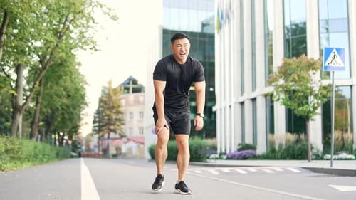Asian runner athlete with muscle pain in city street. Man massaging stretching, trauma injury while