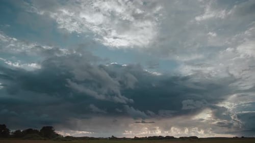Time lapse with storm clouds over field during sunset