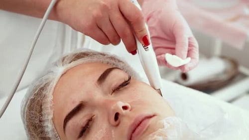 Ultrasonic Exfoliator Being Applied During Facial Care Treatment at Spa Salon Professional Using