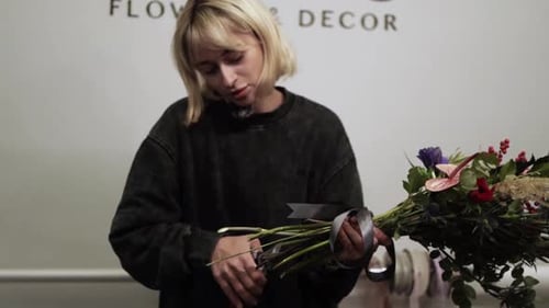 Fleuriste faisant un bouquet dans un magasin de fleurs ES