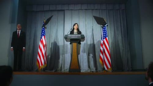 Woman Giving Speech at Podium With United States Flags