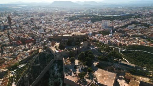 Aerial drone view of the Santa Barbara Castle on the coast of Alicante, Spain with the city on the b
