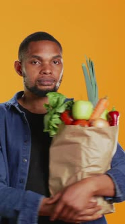 Vertical Video Young Adult Accidentally Dropping an Apple From His Paper Bag
