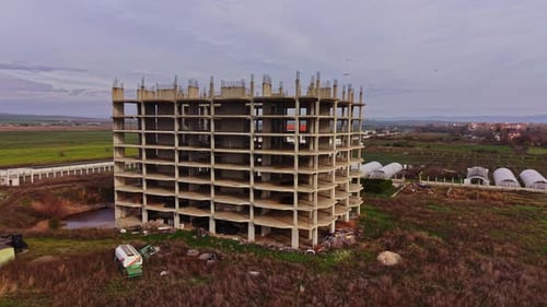Baustelle eines verlassenen Gebäudes, umgeben von Feldern