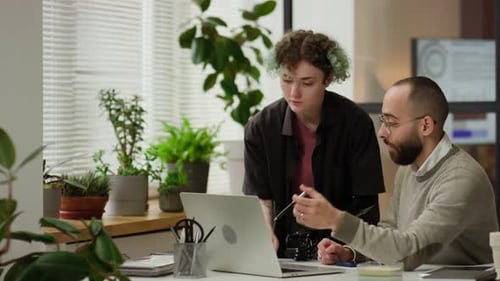 Female Office Worker and Male Manager Discussing Project on Laptop