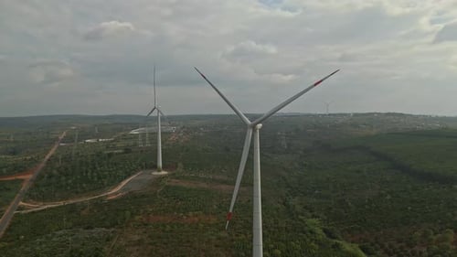 Aerial footage of wind turbines generating clean renewable energy at wind farm.
