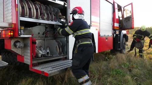 Firefighters Preparing Equipment at Truck in Rural Area