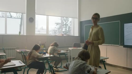 Teacher with students working in classroom at desks