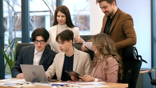 Business meeting in an office, workers discussing business affairs using laptop. Papers with charts