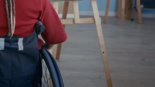 Female Artist in Wheelchair Preparing to Draw Still Life on Canvas in Studio