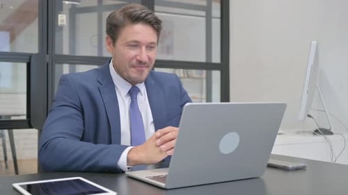 Professional Man in Suit Video Calling On Laptop