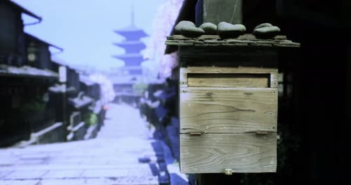 A Wooden Mailbox Stands Near a Cobblestone Path in a Traditional Japanese Town