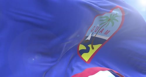 Waving Flag of Guam Against Blue Sky