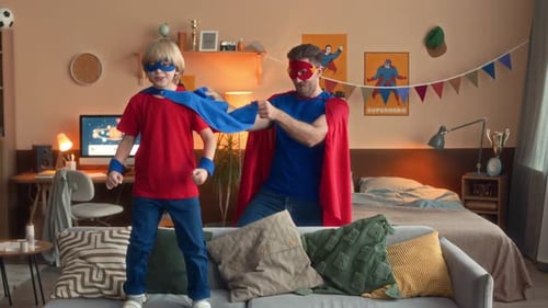 Father and Son Dressed as Superheroes Playing at Home