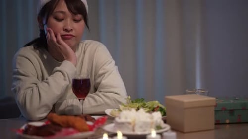 Sad Woman at Holiday Meal with Christmas Hat