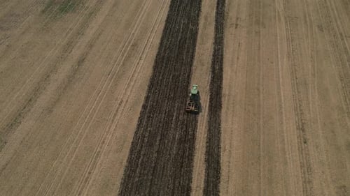 Tractor Plowing Agricultural Field. Cultivating Arable Land For Seeding. Aerial Shot
