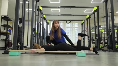 Woman Doing Leg Lifts With Personal Trainer