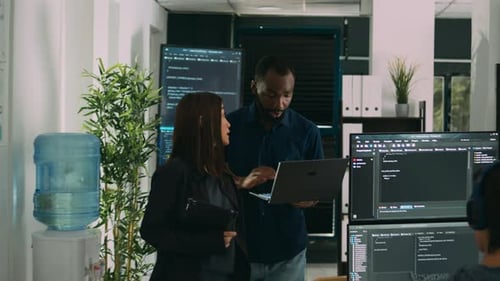 Dois codificadores de software analisando o código-fonte em busca de erros no laptop