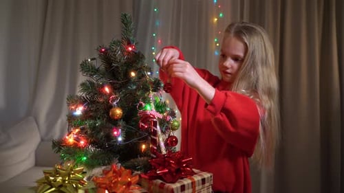 Girl Decorating a Christmas Tree at Home
