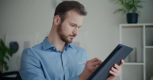 Adult Male Using Tablet and Stylus Indoors