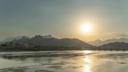 Time laps on the riverbank, sunset over the mountain