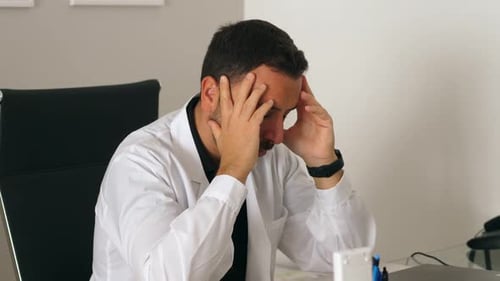 Worried Doctor Experiences Headache in Clinic