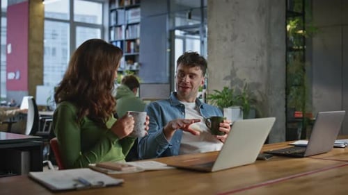Colleagues Discuss Work Over Coffee at Office