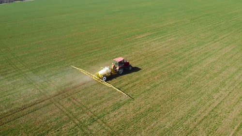 Aerial View of Farming Tractor Spraying on Field with Sprayer Herbicides and Pesticides