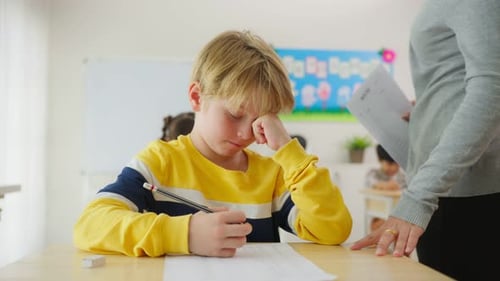 Caucasian young boy student doing an exam test at elementary school.