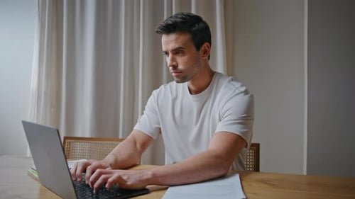 Man Typing on Laptop at Home Office