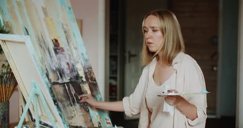Creative Artist Painting on Canvas with Palette Knife at Studio