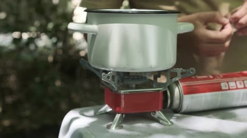 Tourist Gas Burner Close Up Camping Pot is on Portable Camping Gas Stove Water is Heated Camping