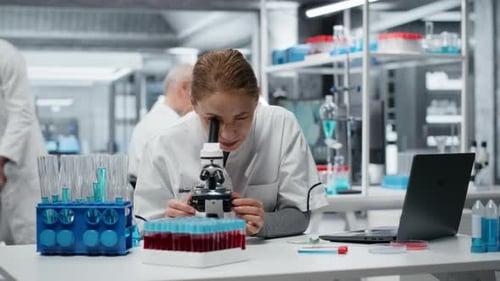 Clinical Microbiologist Using Compound Microscope for Detailed Cellular Analysis