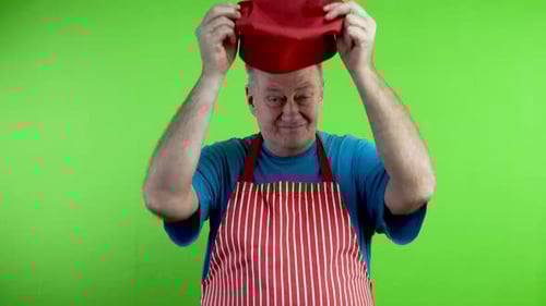 Man in Apron Changes Hats on Green Screen