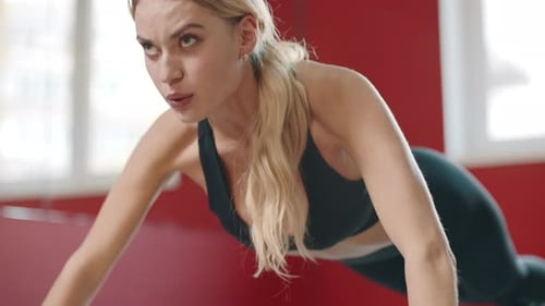 Fitness Woman Pushing Up Exercise on Floor in Sport Club. Young Woman