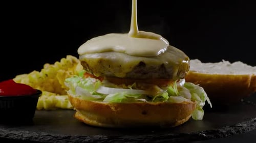 Scharfe Käsesauce auf einen Cheeseburger gegossen