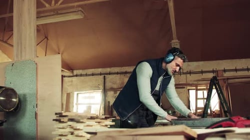 A Man Worker In The Carpentry Workshop, Working With Wood.