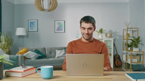 Man works at a laptop and drinks coffee