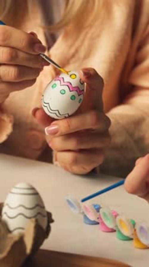 Person Hand-painting A Decorative Easter Egg With A Paintbrush. - closeup shot