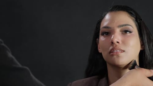 Makeup artist applies makeup to model's face