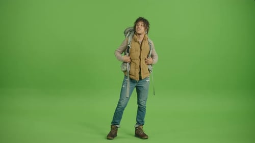 Man With Backpack Stands Against Green Screen