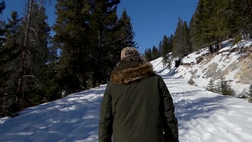 Man walking on snowy path in slow motion
