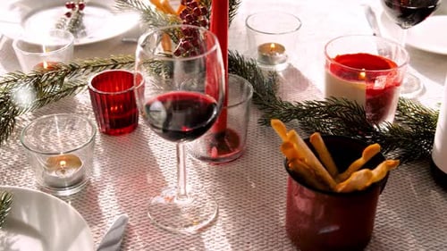 Christmas table setting with wine, candles, and decor