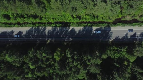 Top View of Cars Driving on Road Surrounded By Green Forests in Countryside Irrl