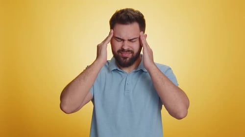Man Experiencing Headache Puts Hands to Temples