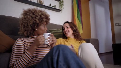 Women Relaxing on Couch with LGBTQ Pride Flag